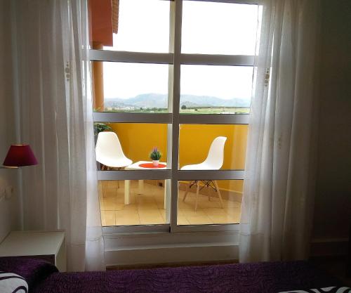 - une fenêtre avec 2 chaises et une table dans la chambre dans l'établissement Hotel Restaurante Campomar, à Carthagène