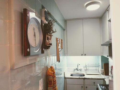 cocina con reloj en la pared y fregadero en DEPARTAMENTO CENTRO PENÍNSULA, en Punta del Este