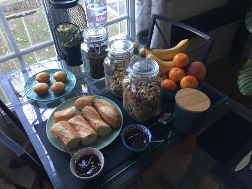 a table topped with plates of bread and fruit at B&B Au bois dormant chambres d hotes in Tillé
