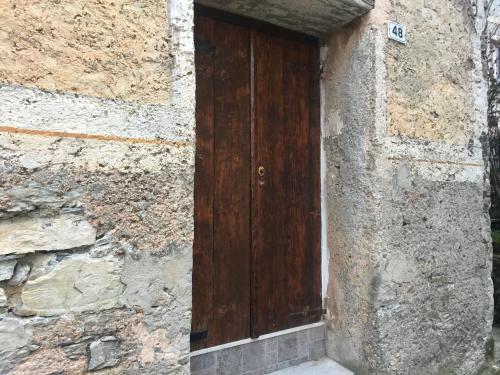 ジェノヴァにあるGenova casa in campagnaの石造りの建物側の木製の扉