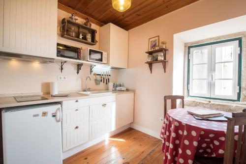 a kitchen with white cabinets and a table and a window at Alfama Apartment in Lisbon