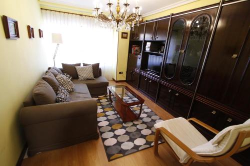 - un salon avec un canapé et un lustre dans l'établissement Apartamento con encanto y vistas en playa San Lorenzo, à Gijón