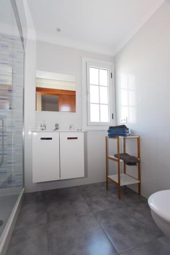 a white bathroom with a sink and a toilet at Casa El Lago in Arrieta
