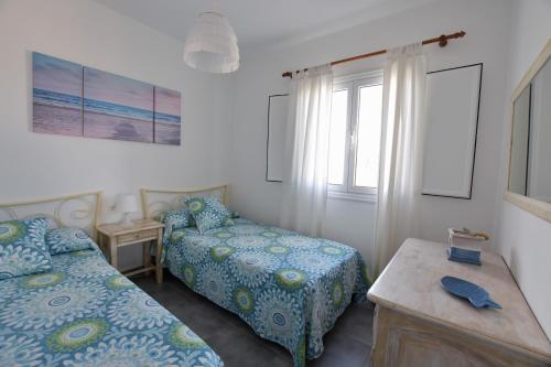 Un dormitorio con dos camas y una mesa y una ventana. en Casa El Lago, en Arrieta