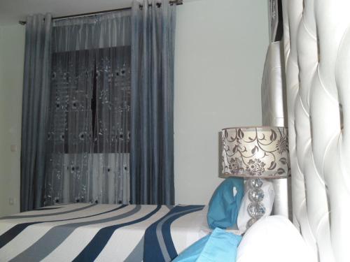 a bedroom with a bed with a lamp and a window at Ferienhaus Vista Mar in Costa Calma