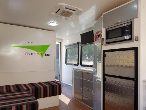 an rv kitchen with a couch and a microwave at Moama on Murray Houseboats in Moama