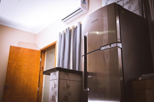 a refrigerator in a kitchen next to a window at Solar Maresias Flats in Maresias