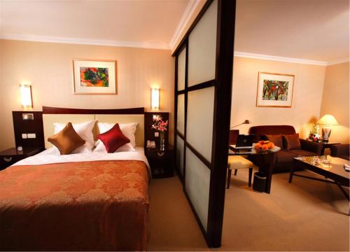 Habitación de hotel con cama y sala de estar. en Jinjiang Fuyuan Hotel en Daxing