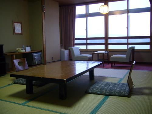 a living room with a coffee table and chairs at Aokiya in Sado