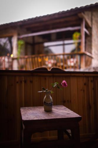 a vase with a flower sitting on a table at Rural House in Yangshuo
