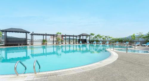 a large swimming pool at a resort with chairs at Bayview Hotel Langkawi in Kuah
