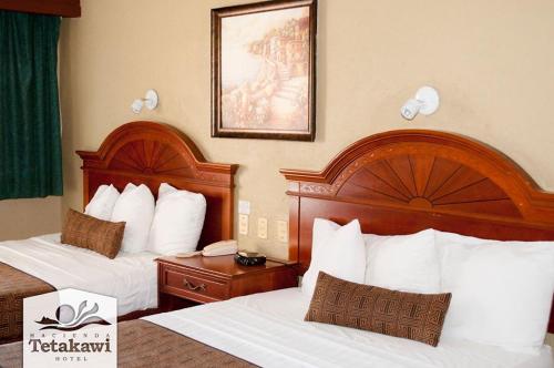 a hotel room with two beds with white pillows at Hotel Hacienda Tetakawi in San Carlos