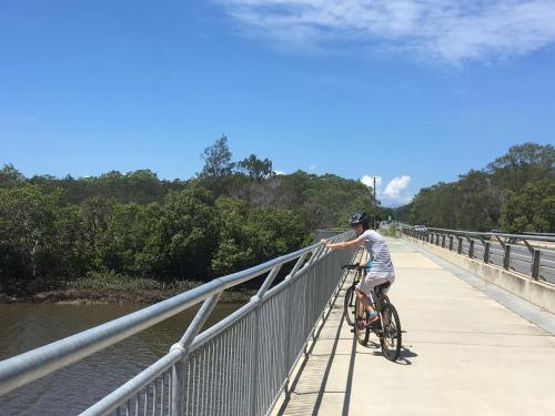 a man riding a bike on a bridge at Absolute Waterfront in Brisbane