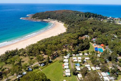an aerial view of a beach with houses and the ocean at Tasman Holiday Parks - Kioloa Beach in Kioloa