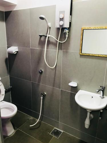 a bathroom with a shower with a sink and a toilet at H-Hotel in Johor Bahru