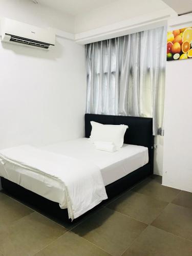 a bedroom with a white bed with a window at H-Hotel in Johor Bahru