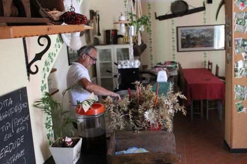 un hombre de pie en una cocina preparando comida en Agriturismo Il Sogno, en Lorsica