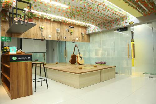 a music shop with a guitar on the wall at Wuhan Worry-free Capsule Hotel in Wuhan