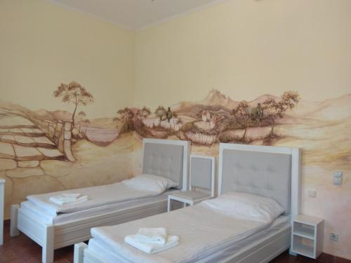 two beds in a room with a mural on the wall at Aparthotel NA DOBU in Lviv