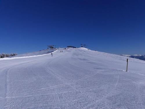 a snow covered hill with people skiing down it at Ferienhaus Bergfee in Klippitztorl
