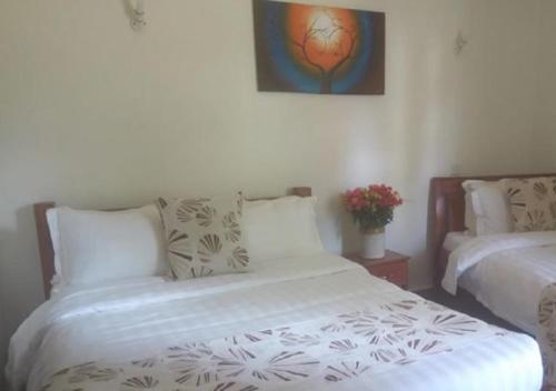 a bedroom with two beds and a painting on the wall at ACK St.Julians Centre in Limuru