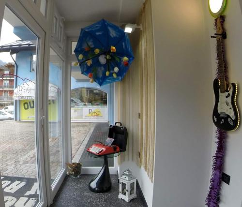a room with a guitar and an umbrella and a stool at B&B Seventy Design in Dimaro