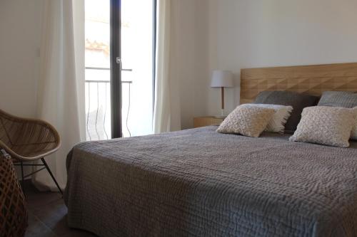 a bedroom with a bed with pillows and a window at Maison Terre Ardente in Caves