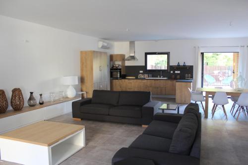 a living room with two couches and a table at Maison Terre Ardente in Caves
