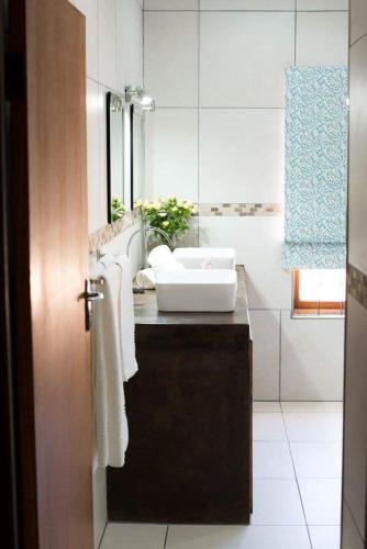 a bathroom with a sink and a mirror and a sink at The Graaff-Reinet Suites in Graaff-Reinet