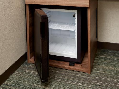 a small refrigerator with its door open in a room at Hearton Hotel Shinsaibashi Nagahoridouri in Osaka