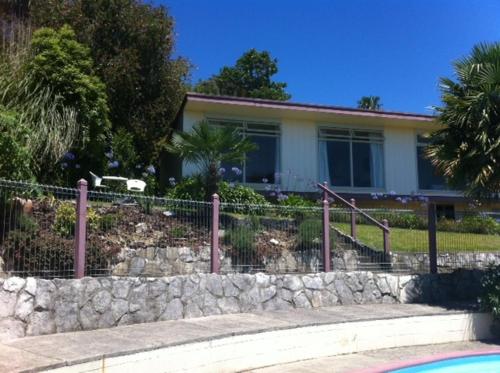 a house with a fence in front of a yard at Panorama Motor Inn in Te Kuiti