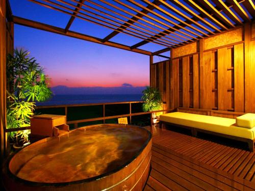 a deck with a bench and a table on a balcony at Itoen Hotel Toi in Izu