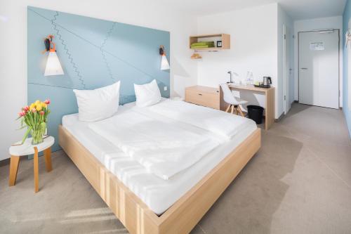 a bedroom with a large bed with a blue wall at Haus KLIPPER Norderney in Norderney