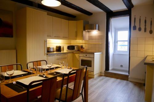 a dining room with a table and chairs and a kitchen at Gîte Grand'Rue "Climatisé" in Colmar