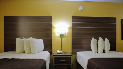 a hotel room with two beds with white pillows at Southern Inn Lumberton in Lumberton