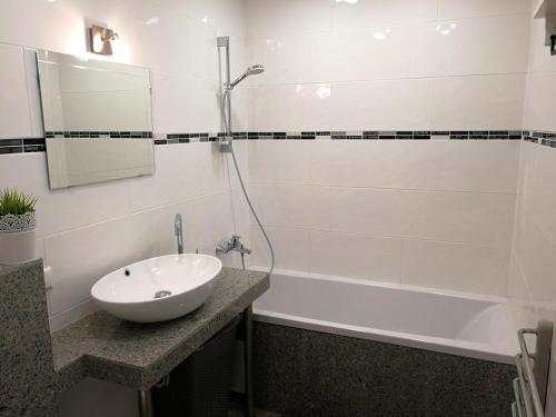 a white bathroom with a sink and a bath tub at Vilnius apartment with stained glass in Vilnius