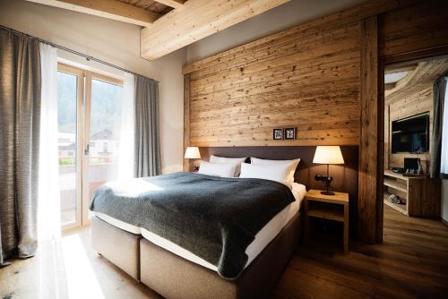 a bedroom with a large bed with a wooden wall at Galzig Lodge in Sankt Anton am Arlberg