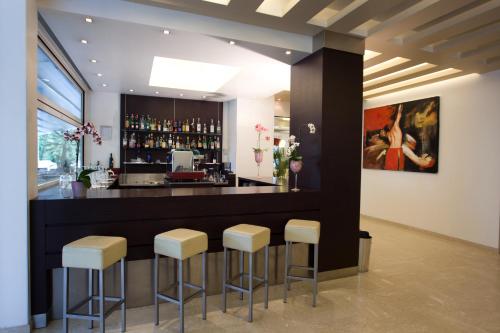 a bar with stools in front of a counter at Hotel Panama Majestic in Rimini