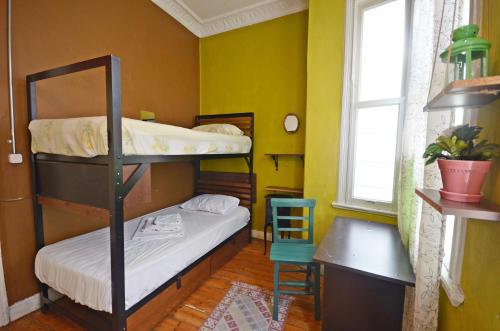 a room with two bunk beds and a desk and a window at Jumba Hostel in Istanbul