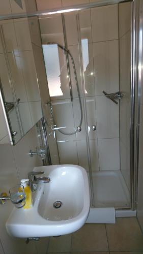 a bathroom with a white sink and a shower at Pension Bergblick in Ruhpolding