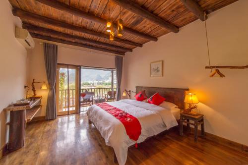 um quarto com uma cama grande e uma varanda em Rural House em Yangshuo
