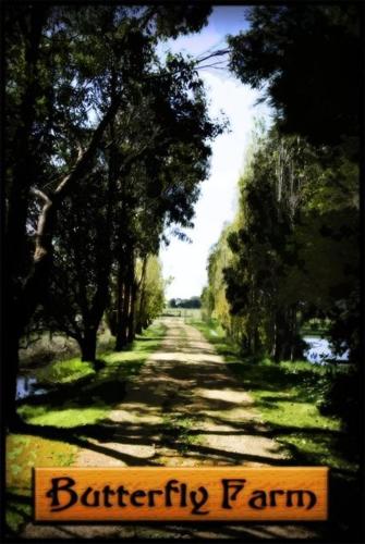 a dirt road with a sign that reads butterfly farm at Butterfly Farm Bed and Breakfast Nirranda in Nirranda