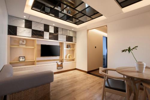 a living room filled with furniture and a tv at GAIA Cosmo Hotel in Yogyakarta