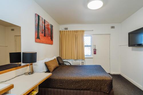 a hotel room with a bed and a tv at Canning Bridge Auto Lodge in Perth