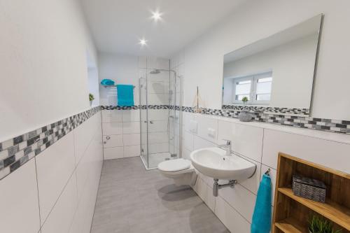 a white bathroom with a sink and a toilet at Ferienwohnung Küstenurlaub Ueckermünde in Ueckermünde