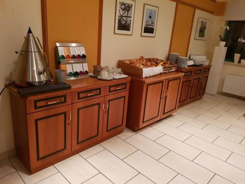 a kitchen with wooden cabinets and a box of food at Hotel Residenz Oberhausen in Oberhausen