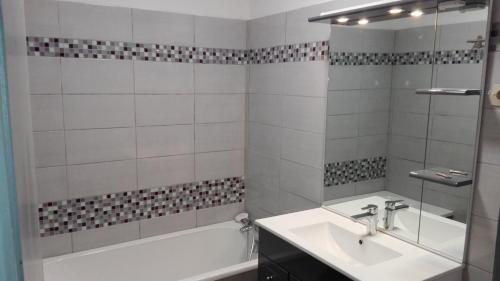 a bathroom with a tub and a sink and a bath tubermottermott at La bressaude - vacances-en-vosges - ménage compris in La Bresse