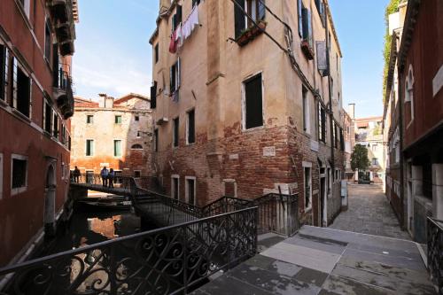 Une allée dans une ville avec des bâtiments et un canal dans l'établissement Antico Fiore Apartments, à Venise
