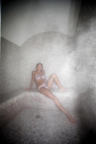 a woman in a bathing suit sitting on a wall at Hotel Panama Majestic in Rimini