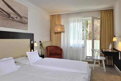 ein Hotelzimmer mit einem Bett, einem Schreibtisch und einem Fenster in der Unterkunft Der Kleine Hans in Sankt Michaelisdonn